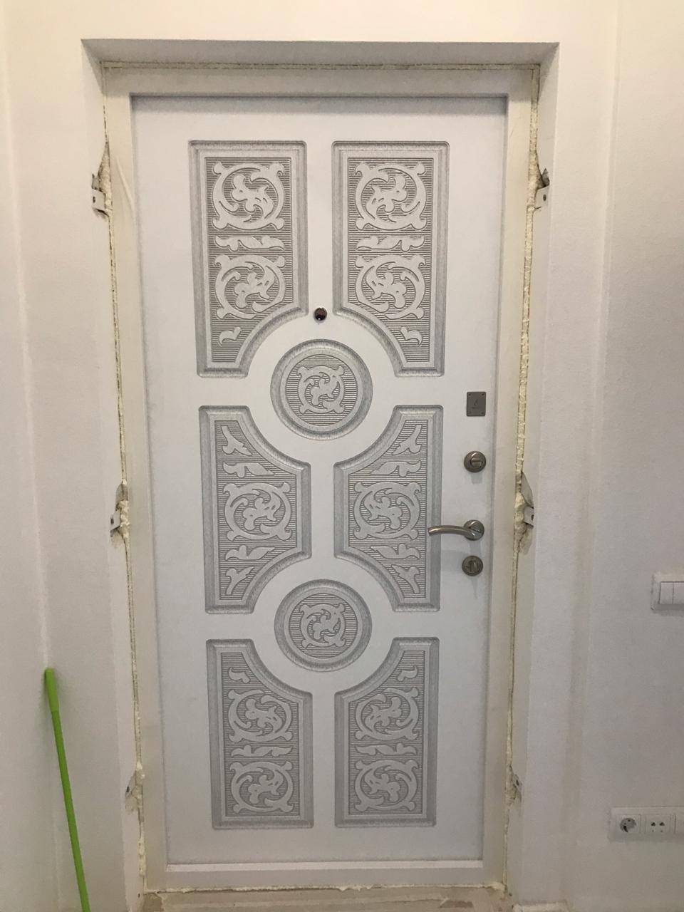 Белая входная дверь с художественной ковкой